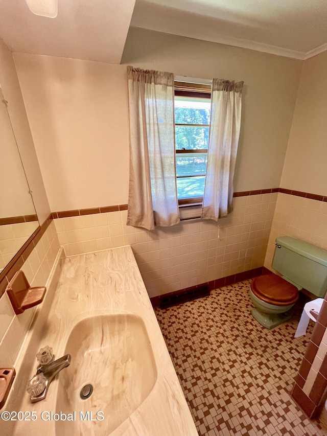 19 Lillian Dr, Glenville, NY 12302 - half bathroom with tile walls, toilet, a wainscoted wall, tile patterned floors, and a sink