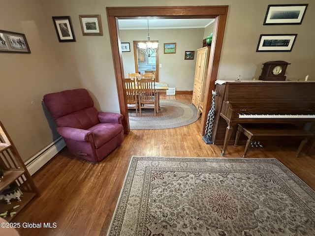 8 Hackett St, Bethlehem, NY 12158 - living area featuring baseboard heating, a chandelier, wood finished floors, ornamental molding, and baseboards