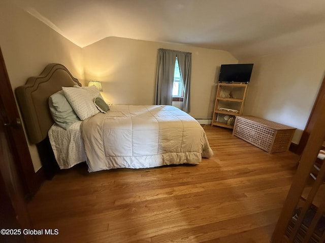 8 Hackett St, Bethlehem, NY 12158 - bedroom featuring vaulted ceiling, a baseboard heating unit, and wood finished floors