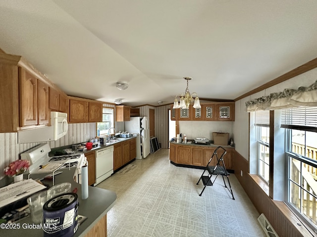 6041 Rte 9n, Hadley, NY 12835 - kitchen featuring white appliances, a chandelier, brown cabinets, pendant lighting, and vaulted ceiling