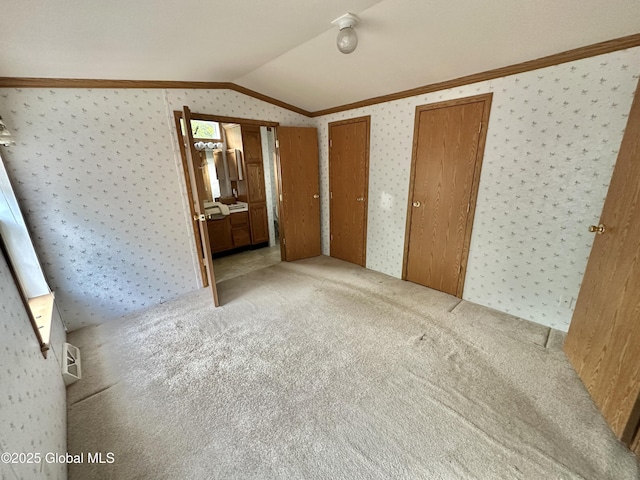 6041 Rte 9n, Hadley, NY 12835 - unfurnished bedroom featuring vaulted ceiling, ornamental molding, carpet flooring, wallpapered walls, and two closets