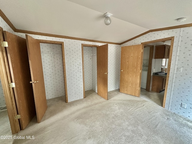 6041 Rte 9n, Hadley, NY 12835 - unfurnished bedroom featuring crown molding, wallpapered walls, vaulted ceiling, light colored carpet, and multiple closets
