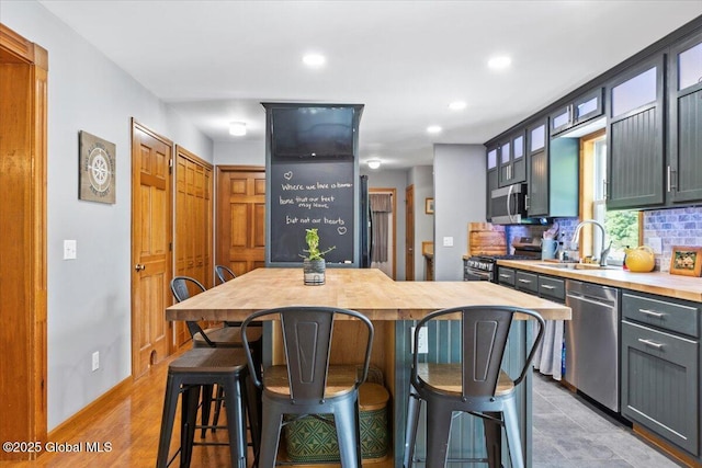 30 Overlook Ct, Claverack, NY 12534 - kitchen with appliances with stainless steel finishes, a sink, a kitchen breakfast bar, glass insert cabinets, and recessed lighting