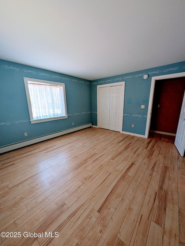 258 Middle Rd, Crown Point, NY 12928 - unfurnished bedroom with hardwood / wood-style floors, a baseboard heating unit, a closet, and baseboards