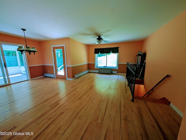 258 Middle Rd, Crown Point, NY 12928 - unfurnished living room featuring baseboard heating, light wood finished floors, baseboards, radiator heating unit, and a chandelier