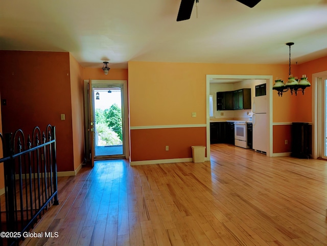 258 Middle Rd, Crown Point, NY 12928 - unfurnished living room featuring a ceiling fan, light wood-style floors, baseboards, and a chandelier