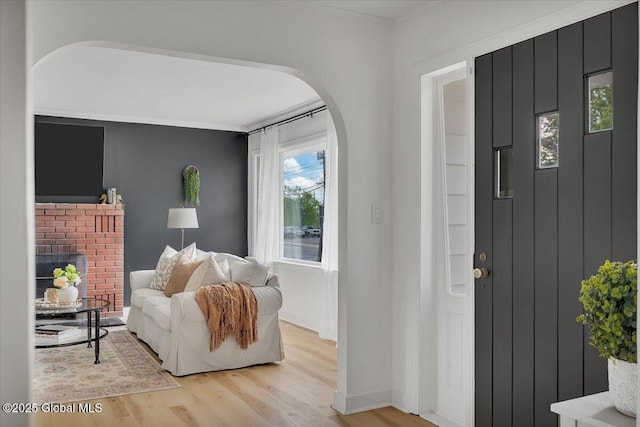 55 Fairview Ave, Hudson, NY 12534 - entryway featuring arched walkways, light wood-type flooring, baseboards, and a brick fireplace
