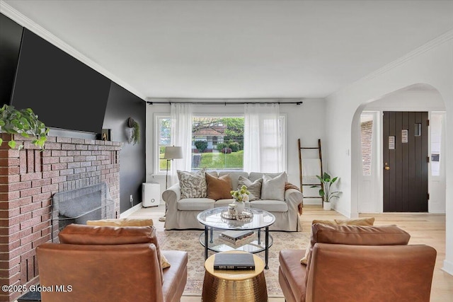 55 Fairview Ave, Hudson, NY 12534 - living area with arched walkways, light wood-type flooring, a fireplace, baseboards, and ornamental molding