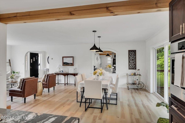55 Fairview Ave, Hudson, NY 12534 - dining room featuring arched walkways, light wood finished floors, and crown molding