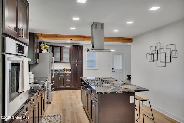 55 Fairview Ave, Hudson, NY 12534 - kitchen with island exhaust hood, appliances with stainless steel finishes, a breakfast bar area, light wood finished floors, and a center island