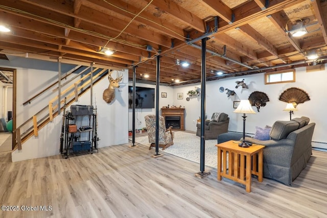 440 Posson Hill Rd, Middleburgh, NY 12122 - below grade area featuring wood finished floors, stairs, a fireplace, and a baseboard radiator