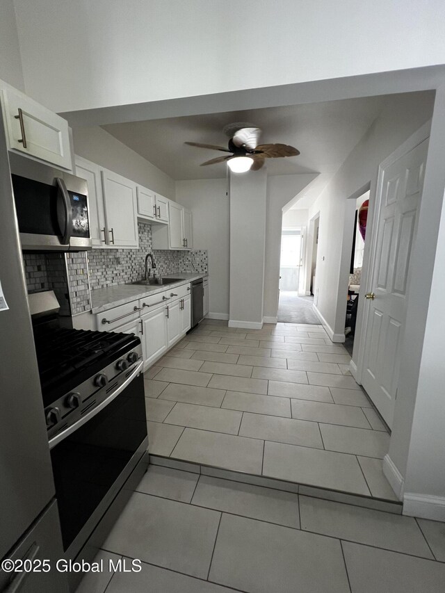 94 Willow Ave, Schenectady, NY 12304 - kitchen featuring stainless steel appliances, a sink, tasteful backsplash, ceiling fan, and white cabinetry