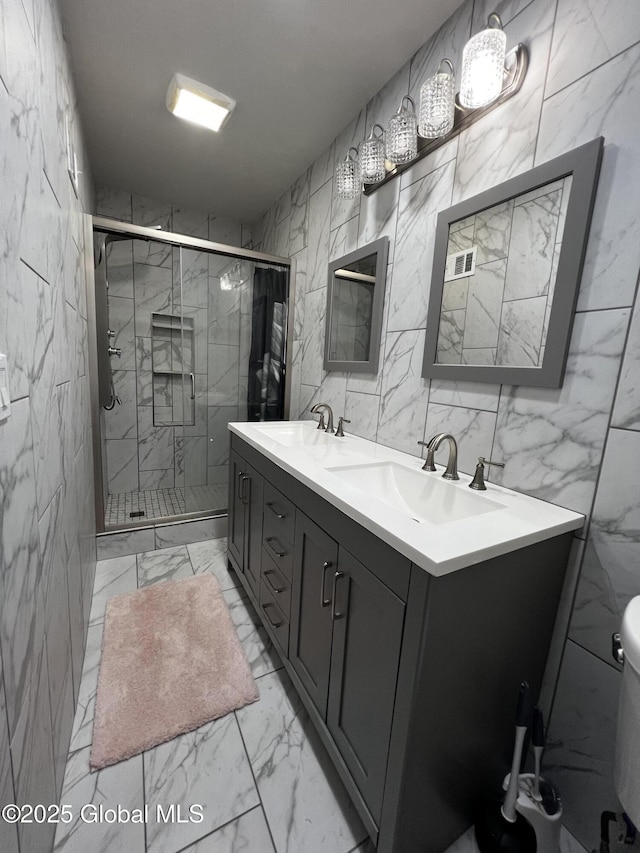 94 Willow Ave, Schenectady, NY 12304 - full bath with marble finish flooring, double vanity, tile walls, a shower stall, and toilet