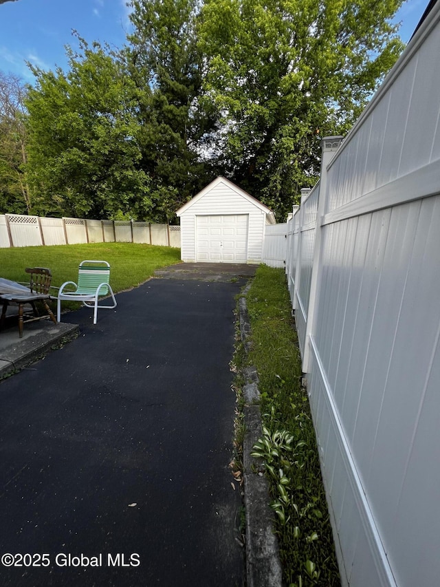 94 Willow Ave, Schenectady, NY 12304 - view of yard with a garage, asphalt driveway, a patio, and an outdoor structure
