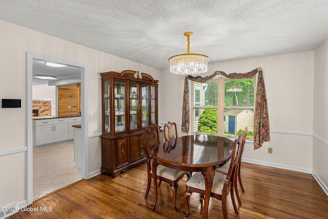 228 Vincenza Ln, Guilderland, NY 12303 - dining area featuring a chandelier, wood finished floors, and a textured ceiling