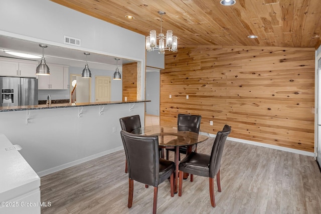 228 Vincenza Ln, Guilderland, NY 12303 - dining room with lofted ceiling, wooden ceiling, light wood finished floors, a chandelier, and wood walls