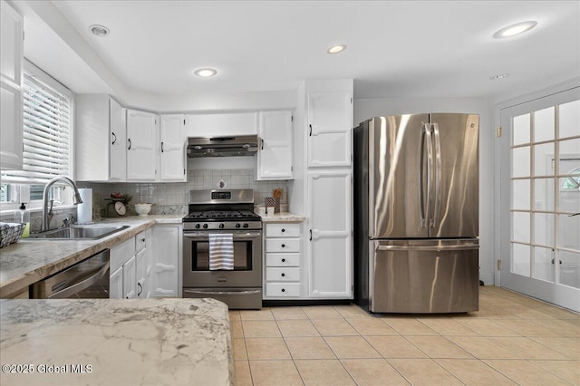 14 Grounds Pl, Colonie, NY 12205 - kitchen with appliances with stainless steel finishes, under cabinet range hood, backsplash, light tile patterned floors, and white cabinetry