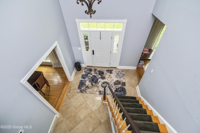 17 Brendan Ln, Niskayuna, NY 12309 - foyer entrance featuring a towering ceiling, baseboards, a chandelier, stairs, and stone finish flooring