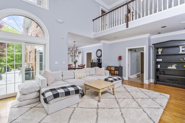 17 Brendan Ln, Niskayuna, NY 12309 - living area featuring a towering ceiling, a chandelier, wood finished floors, ornamental molding, and baseboards