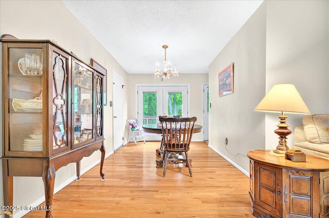 3 N Jordan Dr, Saratoga Springs, NY 12866 - dining area featuring a chandelier, light wood-type flooring, french doors, and a textured ceiling
