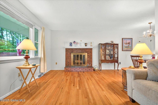 3 N Jordan Dr, Saratoga Springs, NY 12866 - living area with light wood-style floors, a chandelier, and a fireplace
