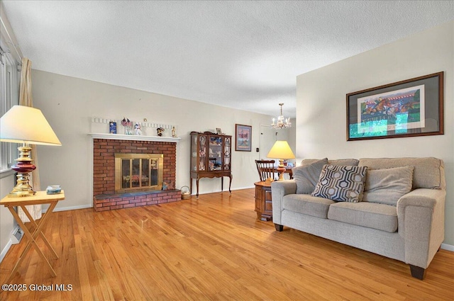 3 N Jordan Dr, Saratoga Springs, NY 12866 - living room featuring a chandelier, light wood-style flooring, a fireplace, and a textured ceiling