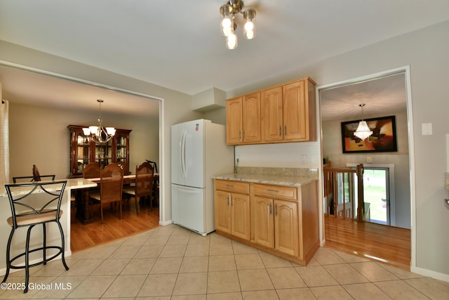 23 Bayberry Dr, Halfmoon, NY 12065 - kitchen with freestanding refrigerator, a chandelier, light tile patterned floors, pendant lighting, and light brown cabinetry