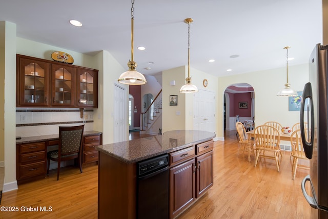 1 Avalon Ct, Colonie, NY 12211 - kitchen featuring freestanding refrigerator, light wood-style flooring, arched walkways, decorative backsplash, and glass insert cabinets