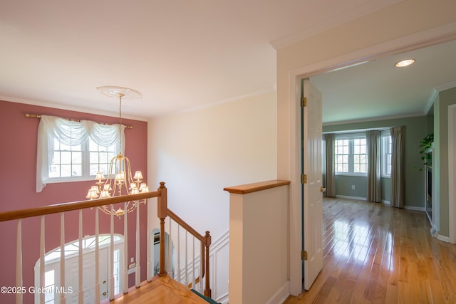 1 Avalon Ct, Colonie, NY 12211 - hallway with an upstairs landing, a chandelier, ornamental molding, light wood-style flooring, and baseboards