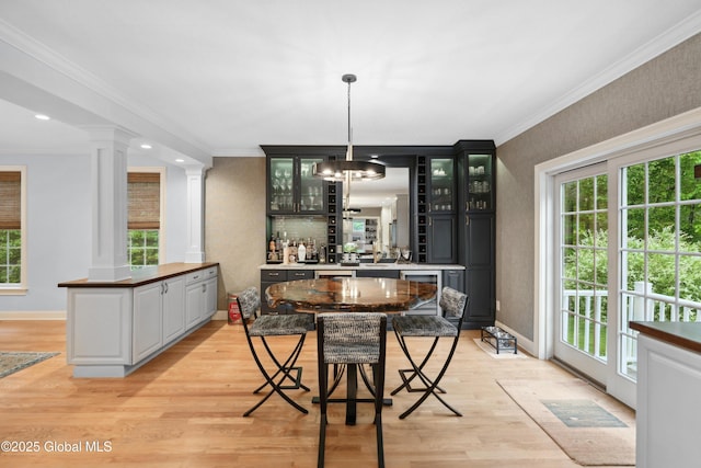 151 Edie Rd, Wilton, NY 12866 - dining area with decorative columns, crown molding, light wood-type flooring, baseboards, and bar area