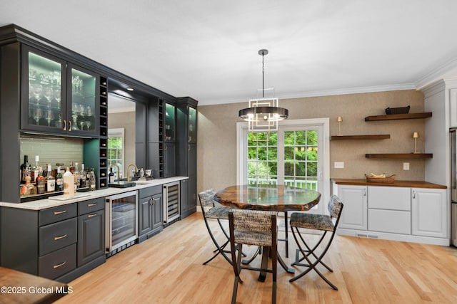 151 Edie Rd, Wilton, NY 12866 - indoor wet bar with beverage cooler, light wood finished floors, crown molding, and healthy amount of natural light