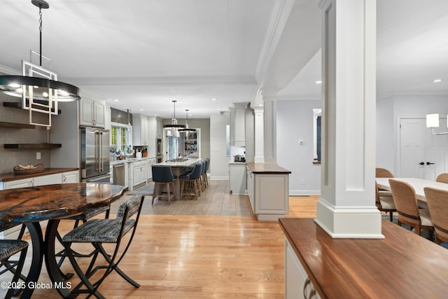 151 Edie Rd, Wilton, NY 12866 - dining room with ornate columns, crown molding, light wood finished floors, baseboards, and recessed lighting