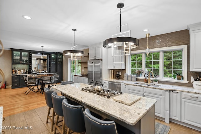 151 Edie Rd, Wilton, NY 12866 - kitchen with stainless steel appliances, a sink, a center island, white cabinetry, and glass insert cabinets