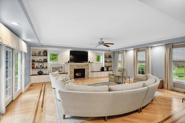 151 Edie Rd, Wilton, NY 12866 - living room with a fireplace, a ceiling fan, light wood-style floors, a raised ceiling, and crown molding