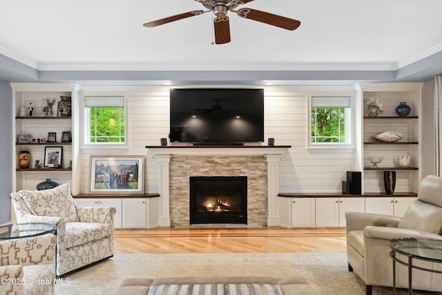 151 Edie Rd, Wilton, NY 12866 - living room with wood finished floors, healthy amount of natural light, ornamental molding, a ceiling fan, and a stone fireplace