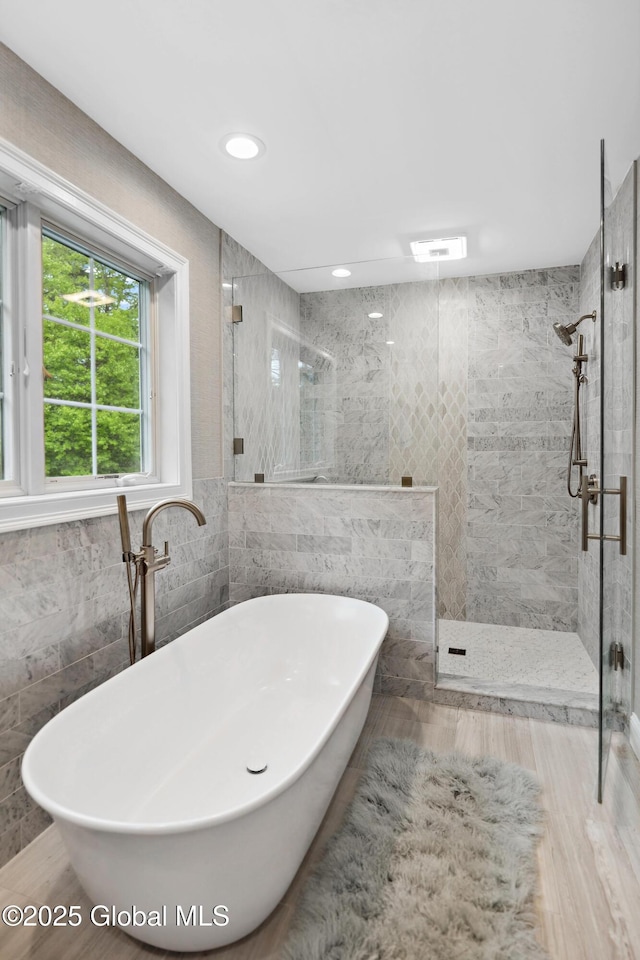 151 Edie Rd, Wilton, NY 12866 - full bathroom with tile walls, a stall shower, a freestanding bath, wood finished floors, and recessed lighting