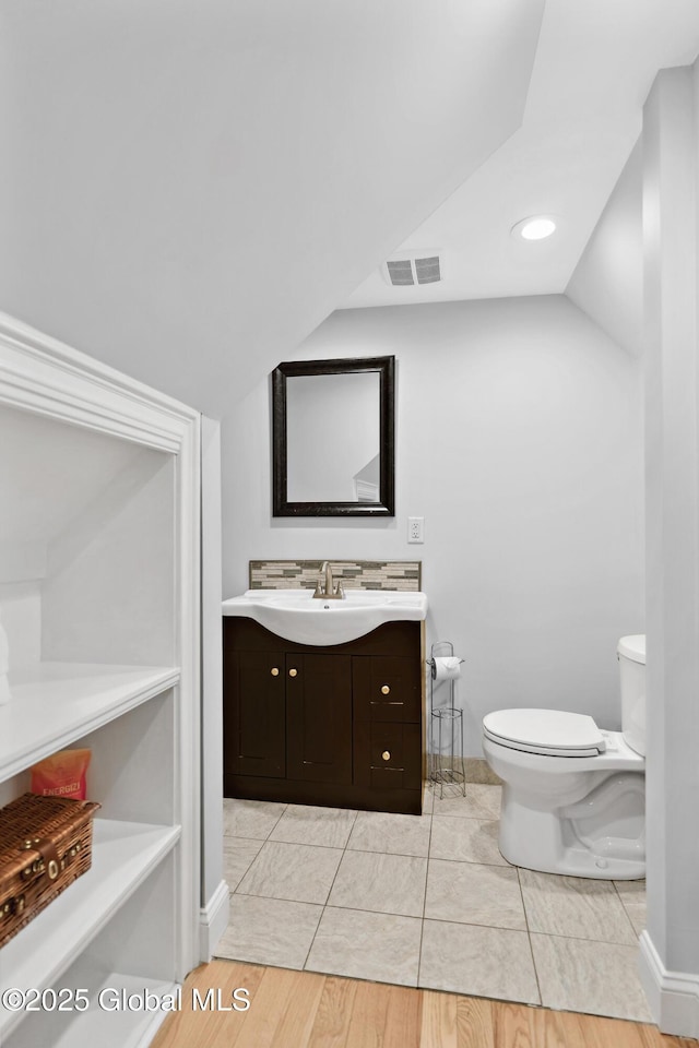 151 Edie Rd, Wilton, NY 12866 - bathroom featuring vanity, toilet, vaulted ceiling, and baseboards
