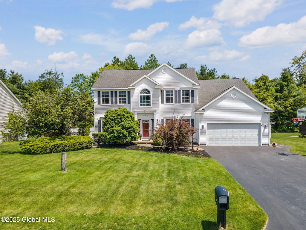 3014 Patrick Rd, Guilderland, NY 12303 - colonial-style house featuring driveway, an attached garage, a front lawn, and roof with shingles