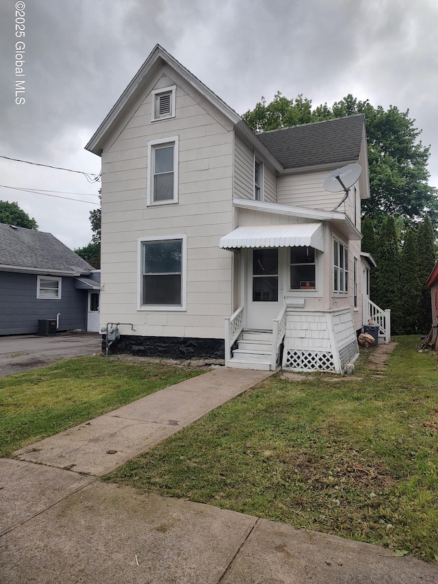 8 Charles St, Ilion, NY 13357 - traditional-style home featuring a front lawn, roof with shingles, and central AC