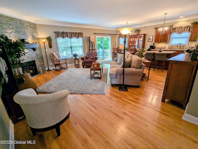 181 Fieldstone Dr, Niskayuna, NY 12304 - living area with light wood-style floors, a stone fireplace, and crown molding