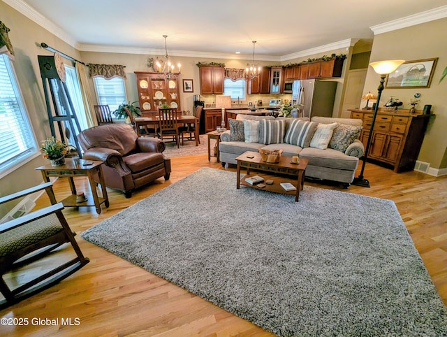 181 Fieldstone Dr, Niskayuna, NY 12304 - living room with a chandelier, light wood finished floors, baseboards, and ornamental molding