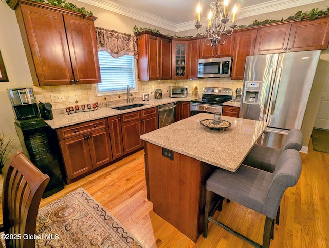 181 Fieldstone Dr, Niskayuna, NY 12304 - kitchen with stainless steel appliances, a sink, a chandelier, a kitchen bar, and light wood-style floors