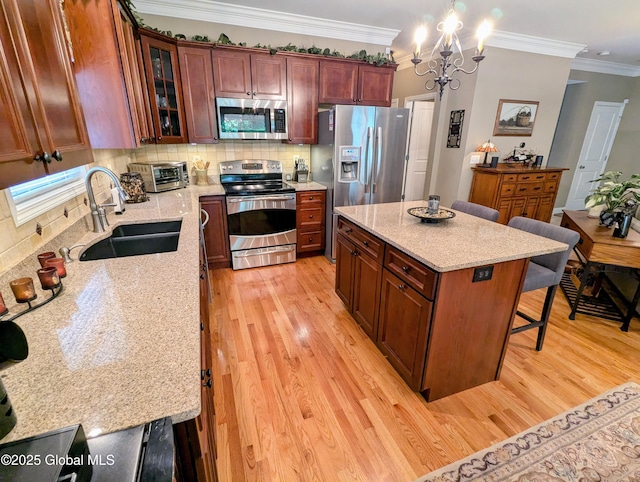 181 Fieldstone Dr, Niskayuna, NY 12304 - kitchen with stainless steel appliances, a sink, a kitchen breakfast bar, tasteful backsplash, and light wood-style floors