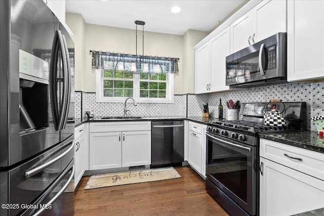 33 White Birch Dr, Lake Luzerne, NY 12846 - kitchen with appliances with stainless steel finishes, a sink, white cabinets, dark wood-type flooring, and tasteful backsplash