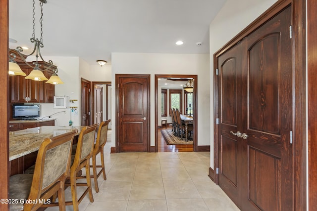 1310 Currybush Rd, Rotterdam, NY 12306 - kitchen featuring light stone countertops, light tile patterned floors, decorative light fixtures, a breakfast bar, and recessed lighting