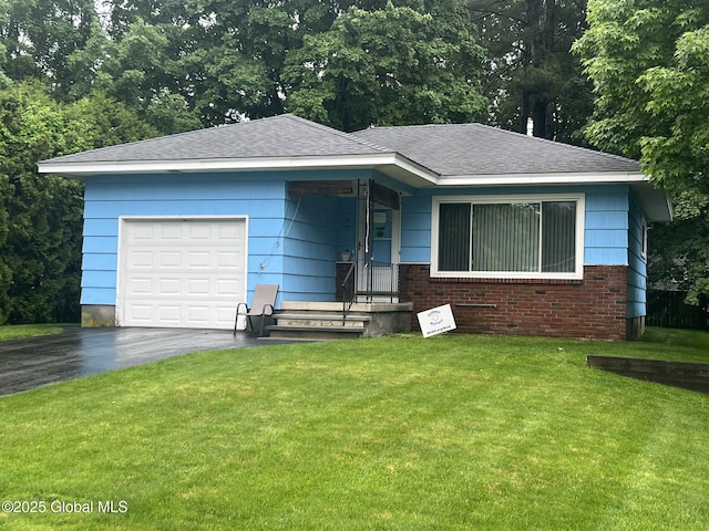 9 Potter St, Glens Falls, NY 12801 - view of front of property featuring asphalt driveway, a front lawn, brick siding, and a garage
