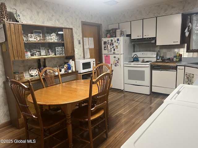 9 Potter St, Glens Falls, NY 12801 - kitchen with white appliances, under cabinet range hood, wallpapered walls, dark wood-style flooring, and washer / dryer