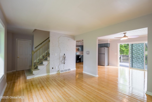 78 Dewitt Ave, Schenectady, NY 12304 - unfurnished living room with light wood finished floors, stairs, a ceiling fan, and baseboards