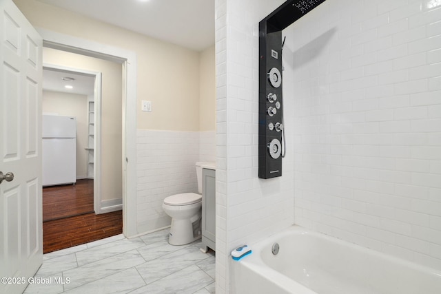 21 Kimball St, Amsterdam, NY 12010 - bathroom with a tub to relax in, toilet, tile walls, marble finish floors, and wainscoting
