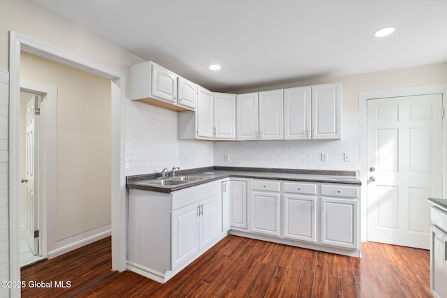 21 Kimball St, Amsterdam, NY 12010 - kitchen featuring a sink, dark countertops, dark wood finished floors, white cabinets, and decorative backsplash